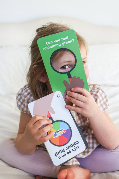 Child holding a colour hunt educational game 