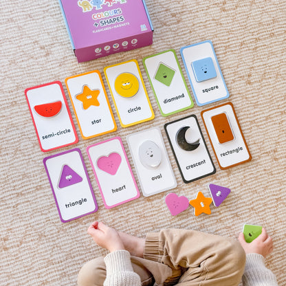 Educational card game with shapes and colours on a carpeted floor, child&